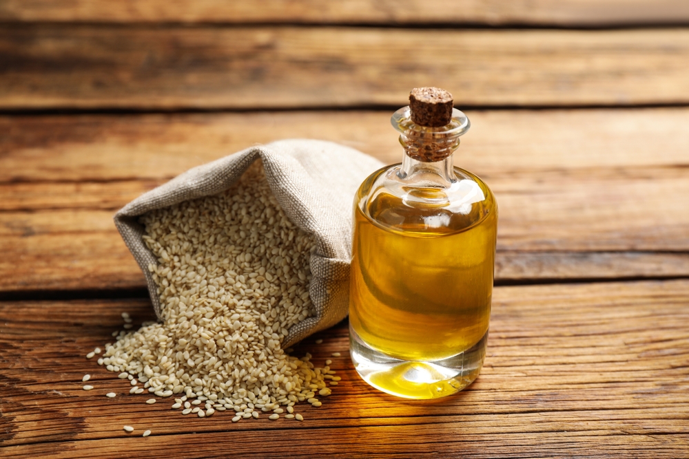 bottle,of,sesame,oil,and,seeds,on,wooden,table